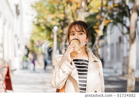 A woman wearing a trench coat and bra in the city 81724882
