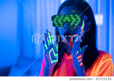 Neon asian woman dancing. Fashion model woman in neon light, portrait of beautiful model with fluorescent make-up, Art and future design of female disco dancer posing in UV, colorful make up. Neon asian woman dancing. Fashion model woman in neon light, portrait of beautiful model with fluorescent make-up, Art and future design of female disco dancer posing in UV, colorful make up. 81725238