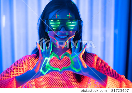 Neon  asian woman dancing. Fashion model woman in neon light, portrait of beautiful model with fluorescent make-up, Art and future design of female disco dancer posing in UV, colorful make up. 81725497