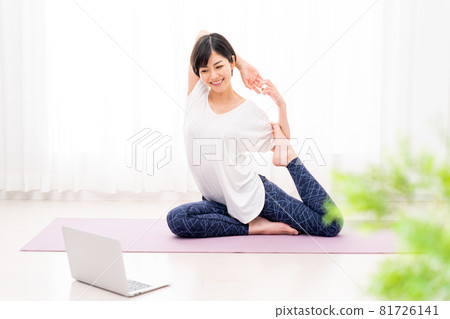 一名年輕女子在做在線瑜伽。 81726141