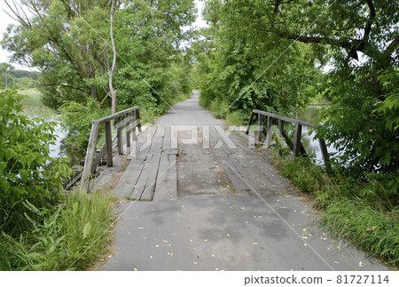 Beautifully standing old wooden bridge over river in colored background 81727114