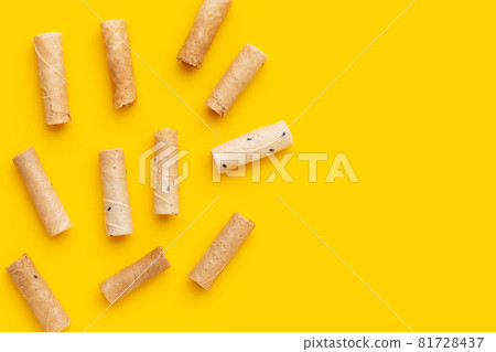 Thai crispy coconut rolls on yellow background. Thai crispy coconut rolls on yellow background. 81728437