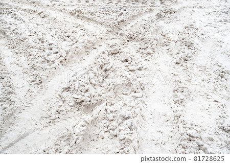 tire tracks on snow covered surface of city road on winter day 81728625