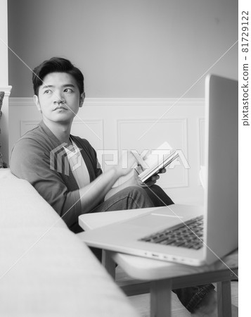 年輕的亞洲男人在家放鬆時看書 年輕的亞洲男人在家放鬆時看書 81729122