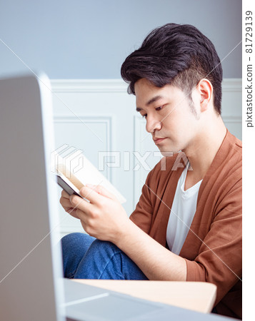 年輕的亞洲男人在家放鬆時看書 81729139