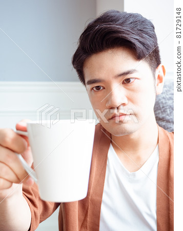 Handsome young Asian male drinking drink at home Handsome young Asian male drinking drink at home 81729148