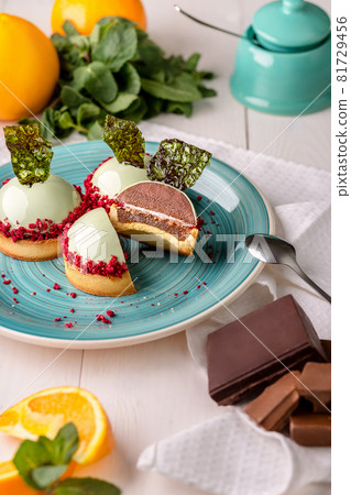 Delicious orange and chocolate cakes in the mirror mint glaze. Delicious orange and chocolate cakes in the mirror mint glaze. 81729456