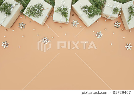 Christmas gift boxes and fir tree on beige background Christmas gift boxes and fir tree on beige background 81729467