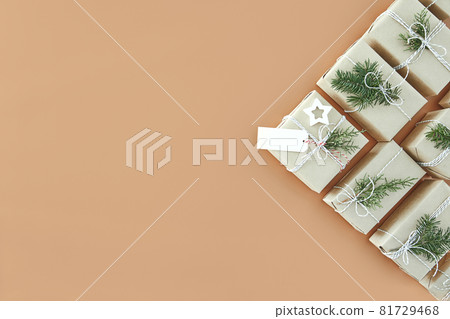Christmas gift boxes and fir tree on beige background Christmas gift boxes and fir tree on beige background 81729468