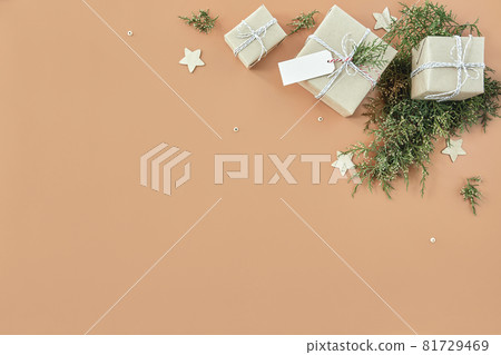 Christmas gift boxes and fir tree on beige background Christmas gift boxes and fir tree on beige background 81729469