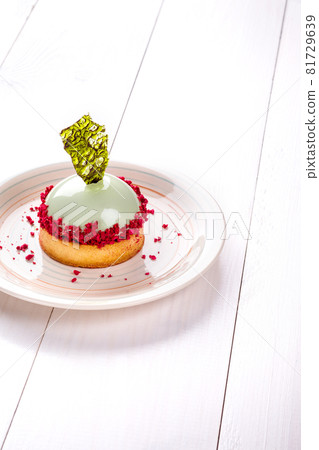 Small cake with different stuffing on a white plate. White wooden table. Small cake with different stuffing on a white plate. White wooden table. 81729639