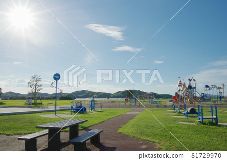 Summer blue sky, sun, white clouds and playset lined up in the park 81729970