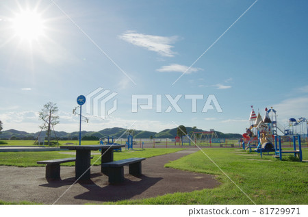 Summer blue sky, sun, white clouds and playset lined up in the park 81729971