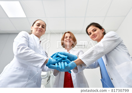 Hands in blue gloves covid, concept - creative team with hands on top of each other. Diverse team putting their hands together. One for all gesture in gloves. Covid-19 concept. 81730799