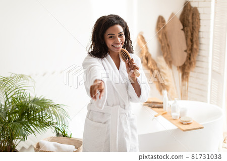 Cheerful African American Woman Singing With Hair Brush In Bathroom Cheerful African American Woman Singing With Hair Brush In Bathroom 81731038