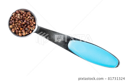 top view of grains of paradise pepper in measuring teaspoon cutout on white background 81731324