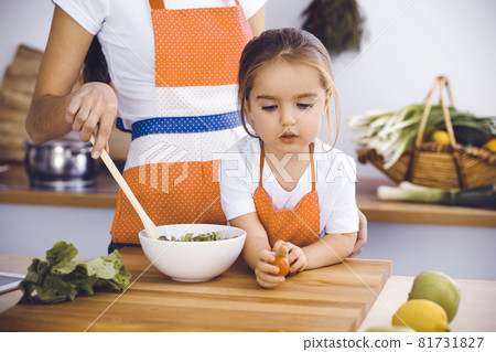 Happy woman and her daughter making healthy vegan salad and snacks for family feasting. Christmas, New year, Thanksgiving, Anniversary, Mothers Day. Healthy meal cooking concept 81731827