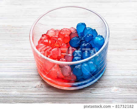 red and blue colored boiled tapioca balls in glass bowl on gray wooden table red and blue colored boiled tapioca balls in glass bowl on gray wooden table 81732182