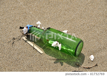 A glass bottle with shells attached washed up on a beach in Esashi, Hokkaido in early autumn 81732769