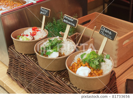 Bowld with to go meals at farmers market. Takeaway stall, bean goulash, Moroccan vegetables and Ghana Masala at the farmers market in Prague Karlin. 81733656