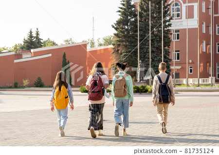 Group of schoolkids with backpacks going to school in the morning 81735124
