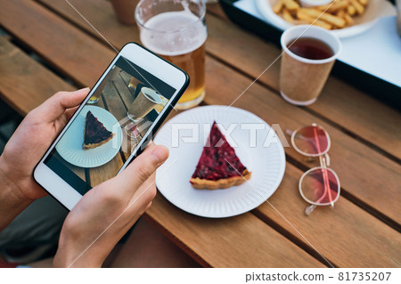 Hands of young female with smartphone taking photo of tasty cake Hands of young female with smartphone taking photo of tasty cake 81735207