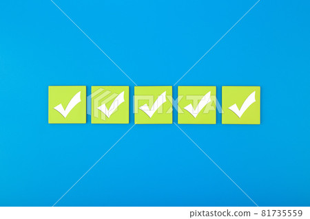 Five checkmarks on bright green tablets in the middle of blue background Five checkmarks on bright green tablets in the middle of blue background 81735559