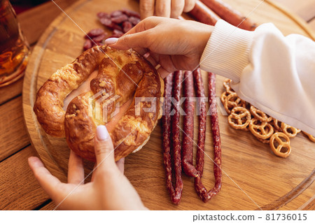 Close-up male hand with beer snacks and beer glasses during Oktoberfest holiday meeting. Traditions, fun, joy, friendship, holidays. October, worldwide holidays, autumn concept Close-up male hand with beer snacks and beer glasses during Oktoberfest holiday meeting. Traditions, fun, joy, friendship, holidays. October, worldwide holidays, autumn concept 81736015