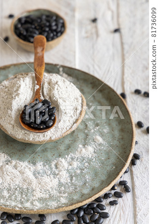 Ceramic bowls with black beans flour with a wooden spoon Ceramic bowls with black beans flour with a wooden spoon 81736099