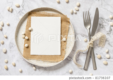 Blank paper card on a plate with little white stones 81736107