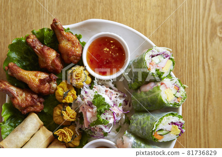 Grilled chicken wings and spring rolls Grilled chicken wings and spring rolls 81736829