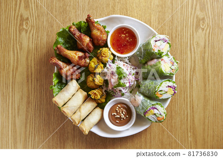 Grilled chicken wings and spring rolls Grilled chicken wings and spring rolls 81736830