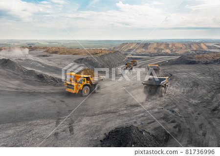 Large quarry dump truck. Big yellow mining truck at work site. Loading coal into body truck. Production useful minerals. Mining truck mining machinery to transport coal from open-pit production 81736996