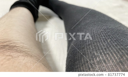 一個女人脫掉毛茸茸的襪子的膝蓋和小腿 一個女人脫掉毛茸茸的襪子的膝蓋和小腿 81737774