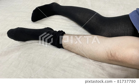 A woman's knees and legs removing her hairy socks A woman's knees and legs removing her hairy socks 81737780