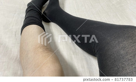 A woman's knees and legs removing her hairy socks 81737783
