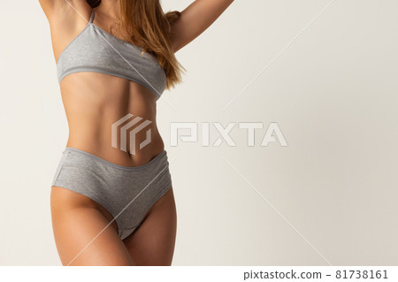 Close-up cropped female body in gray underwear over grey background. 81738161