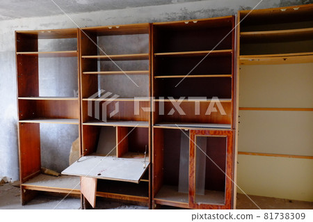 Broken wooden cabinets in an abandoned room. Old Soviet furniture in an abandoned apartment in Pripyat. Broken wooden cabinets in an abandoned room. Old Soviet furniture in an abandoned apartment in Pripyat. 81738309