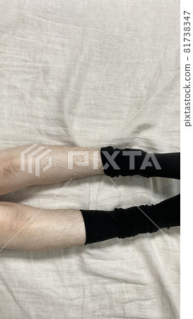 A woman's hairy legs, knees and partially removed socks A woman's hairy legs, knees and partially removed socks 81738347