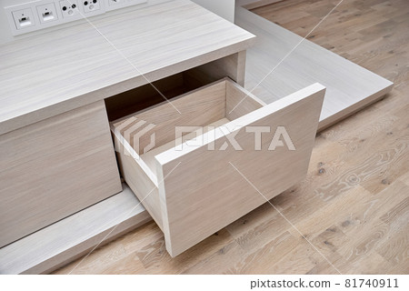 Commode for TV set of white oak lumber with open drawers on a wooden podium 81740911