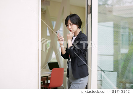 Businesswoman using a smartphone in the office 81745142