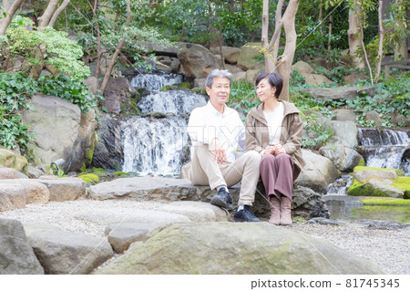 Senior couple trip A good couple talking about memories with a waterfall in the background Senior couple trip A good couple talking about memories with a waterfall in the background 81745345
