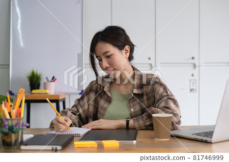 Portrait of cheerful asian woman with casual life on desk in home office. Concept of young business people working at home. 81746999