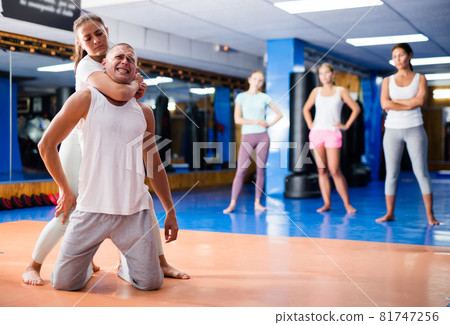 Hispanic female practicing self defence techniques with coach Hispanic female practicing self defence techniques with coach 81747256