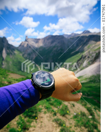 Hiker on high altitude mountain top checking the altimeter on the sports watch 81747961