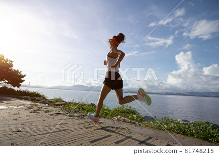Fitness woman running on sunny tropical seaside Fitness woman running on sunny tropical seaside 81748218