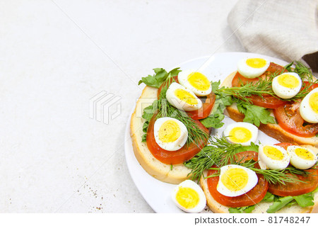 Fresh toast sandwiches with quail eggs, tomatoes and green herbs. Closeup. Top view. Copy space. Fresh toast sandwiches with quail eggs, tomatoes and green herbs. Closeup. Top view. Copy space. 81748247