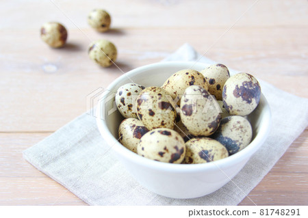 Quail eggs in the white bowl on the rustic background. Concept healthy food. 81748291
