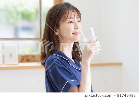 Young woman drinking mineral water in pajamas 81748488