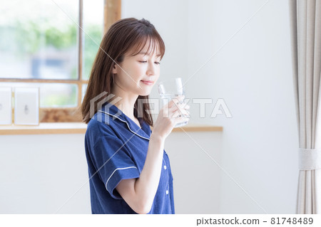 穿著睡衣喝礦泉水的年輕女人 81748489